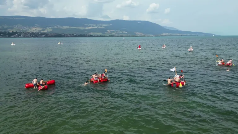 Radeaux dispersés sur le lac, vus de loin avec le Jura au fond, fête d'été Corintis, Moon Suisse