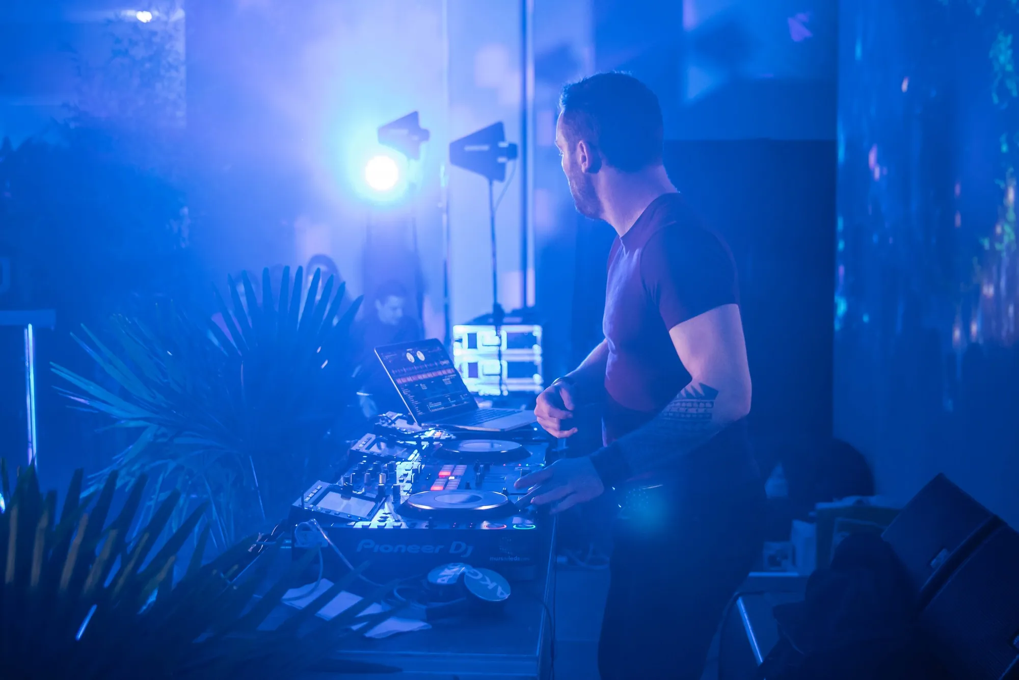 DJ aux platines sous lumière bleue, agence événementielle Moon