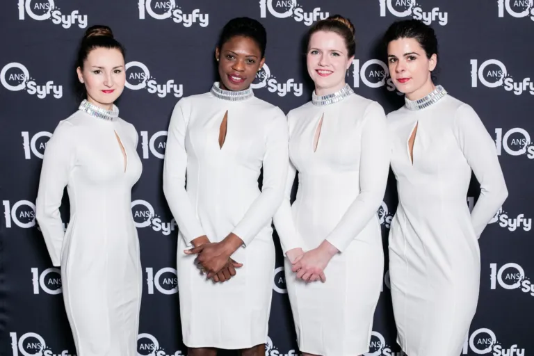 Hôtesses en tenue blanche devant un photocall, agence événementielle Moon