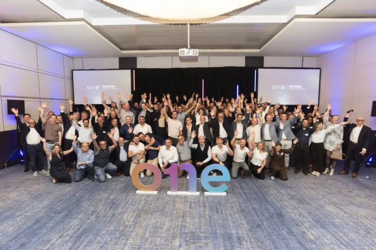 Photo de groupe des collaborateurs dans la salle de plénière des 20 ans d'Acrotec